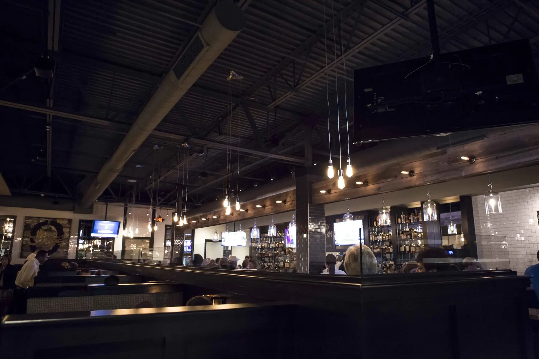 The dining room at night, Edison bulbs hanging over the booths and the back bar